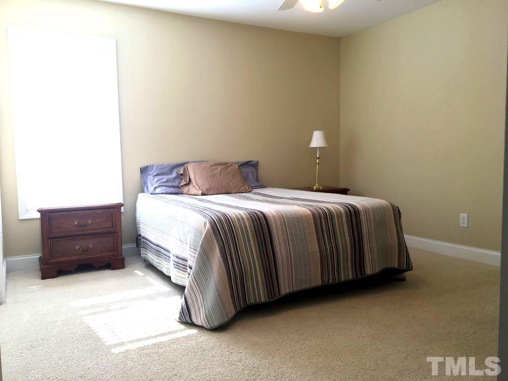 3136 La Costa Way Raleigh, NC 27610 - Photo 16 of 21 a bedroom with a bed and a lamp on dresser