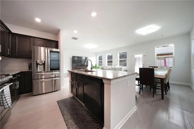 a kitchen with refrigerator cabinets dining table and chairs