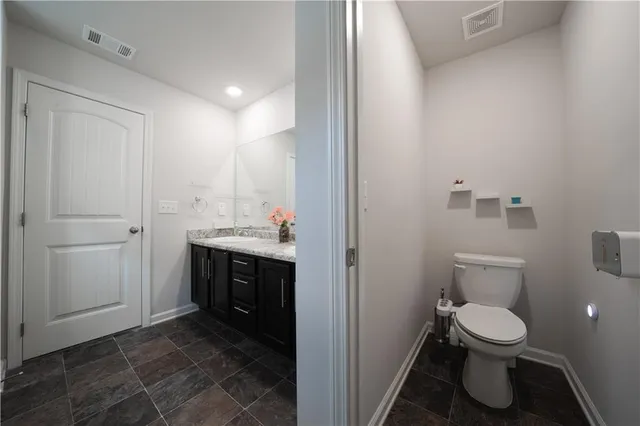 a bathroom with a toilet a sink and mirror