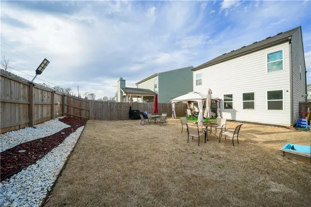 a view of a house with backyard and sitting area