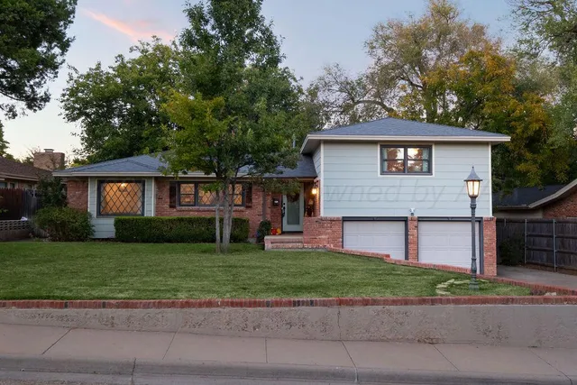 a front view of a house with a garden and yard