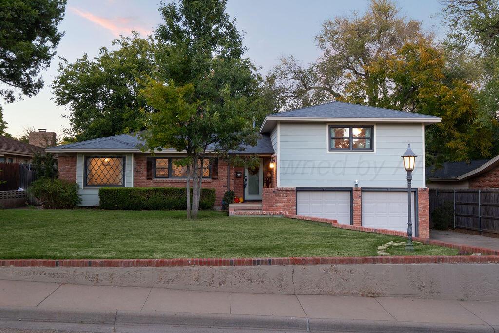 a front view of a house with a garden and yard