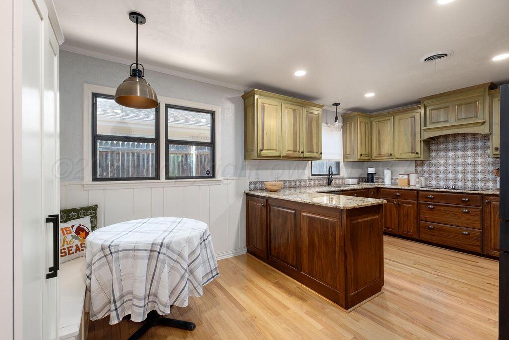 4314 Emil Avenue Amarillo, TX 79106 - Photo 13 of 44 a kitchen with kitchen island granite countertop a sink cabinets and wooden floor