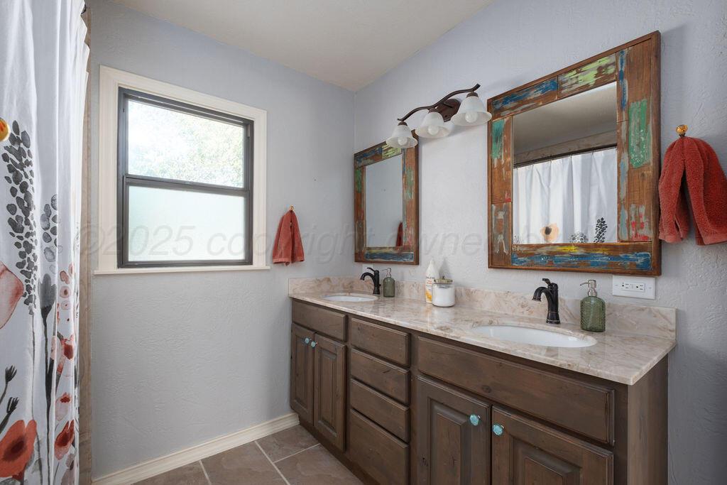 4314 Emil Avenue Amarillo, TX 79106 - Photo 35 of 44 a bathroom with a double vanity sink and mirror