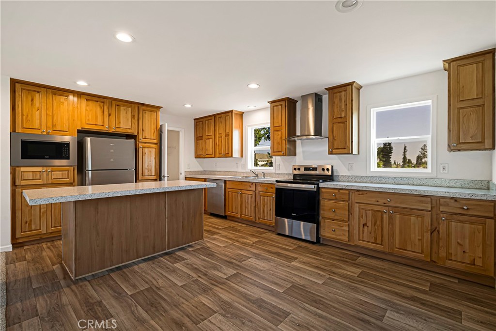 5352 Sawmill Road Paradise, CA 95969 - Photo 3 of 23 a kitchen with stainless steel appliances granite countertop a stove a sink dishwasher a microwave oven and a refrigerator with wooden floor