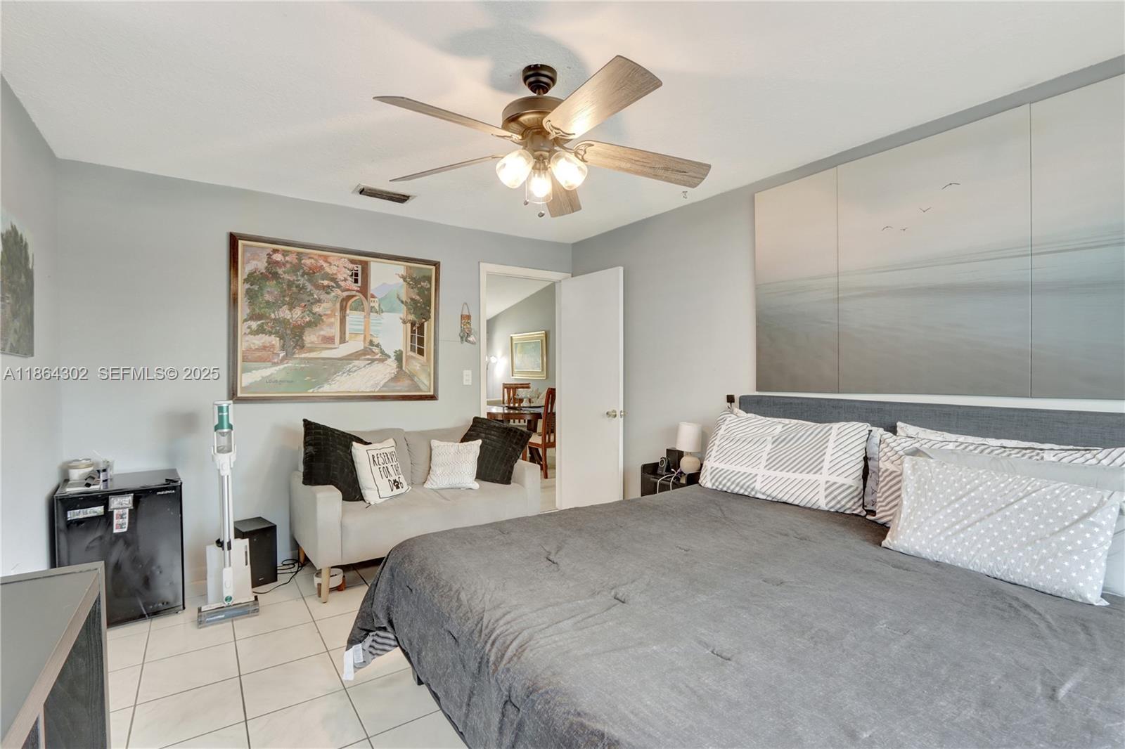 7680 Southwest 156th Court, Unit B113 Miami, FL 33193 - Photo 11 of 16 a bedroom with a large bed and a chandelier