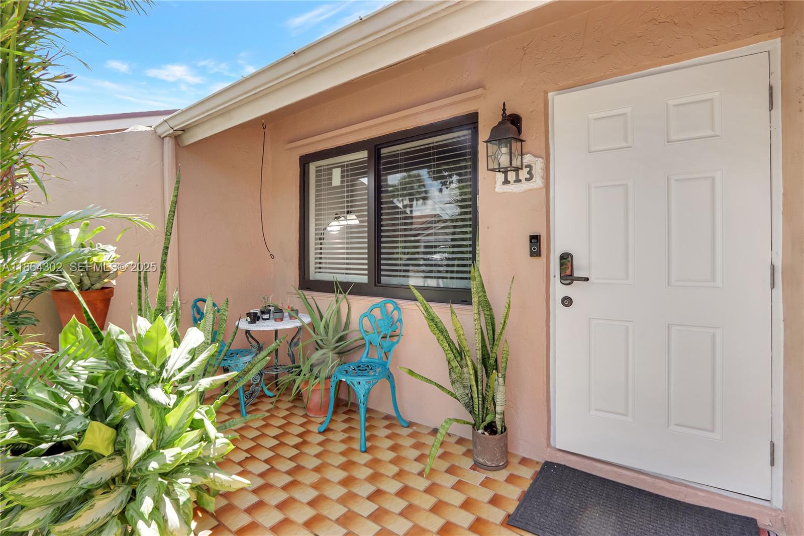 7680 Southwest 156th Court, Unit B113 Miami, FL 33193 - Photo 2 of 16 a potted plant sitting in front of a house