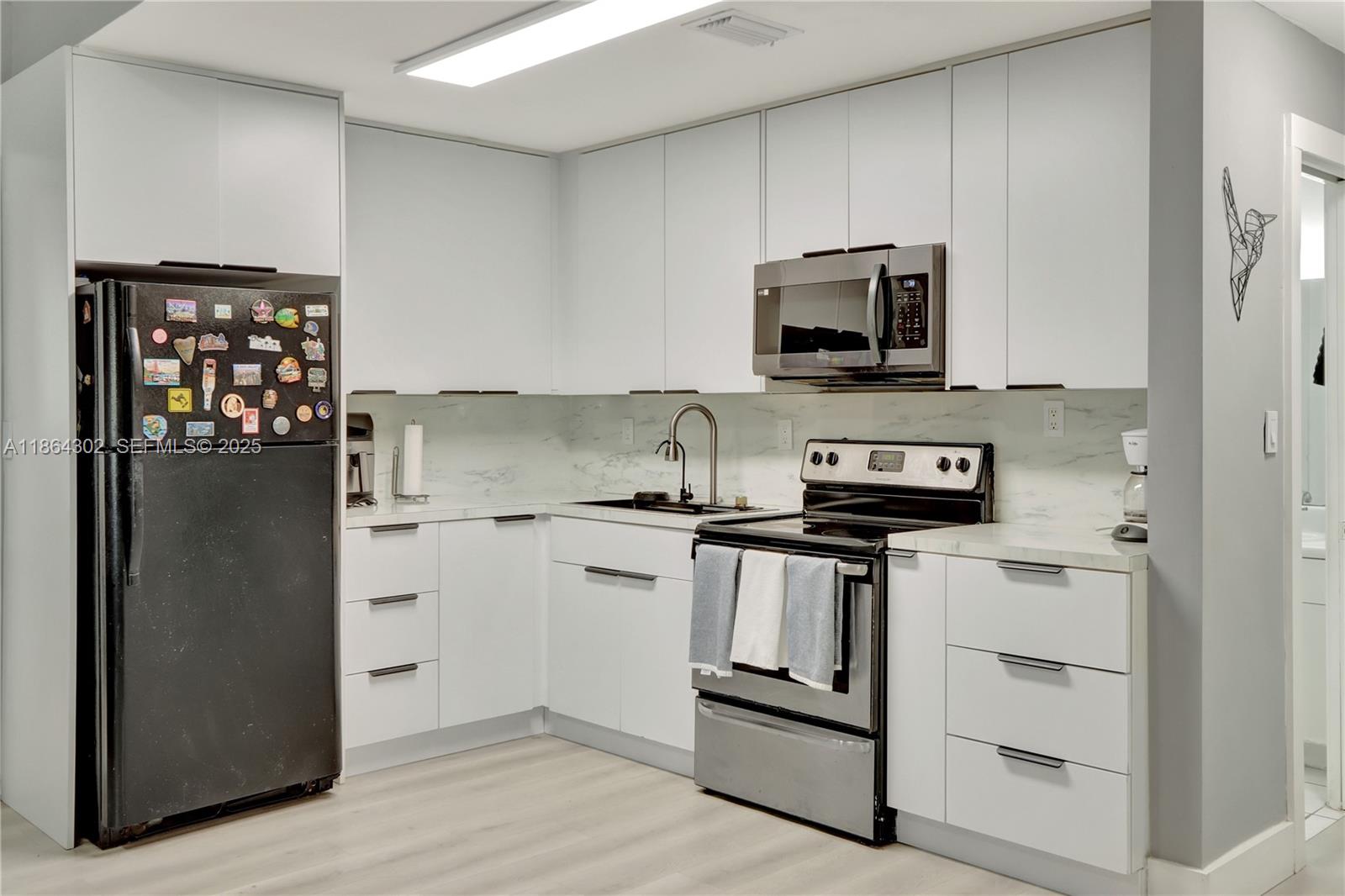 7680 Southwest 156th Court, Unit B113 Miami, FL 33193 - Photo 5 of 16 a kitchen with stainless steel appliances granite countertop a stove and a refrigerator