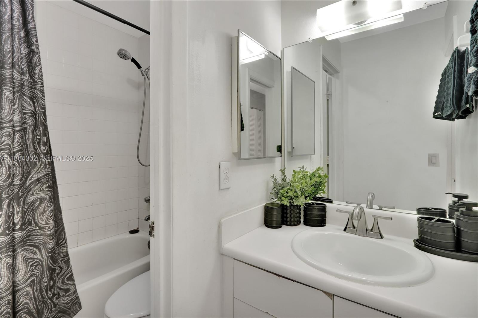 7680 Southwest 156th Court, Unit B113 Miami, FL 33193 - Photo 8 of 16 a bathroom with a sink a toilet and a mirror