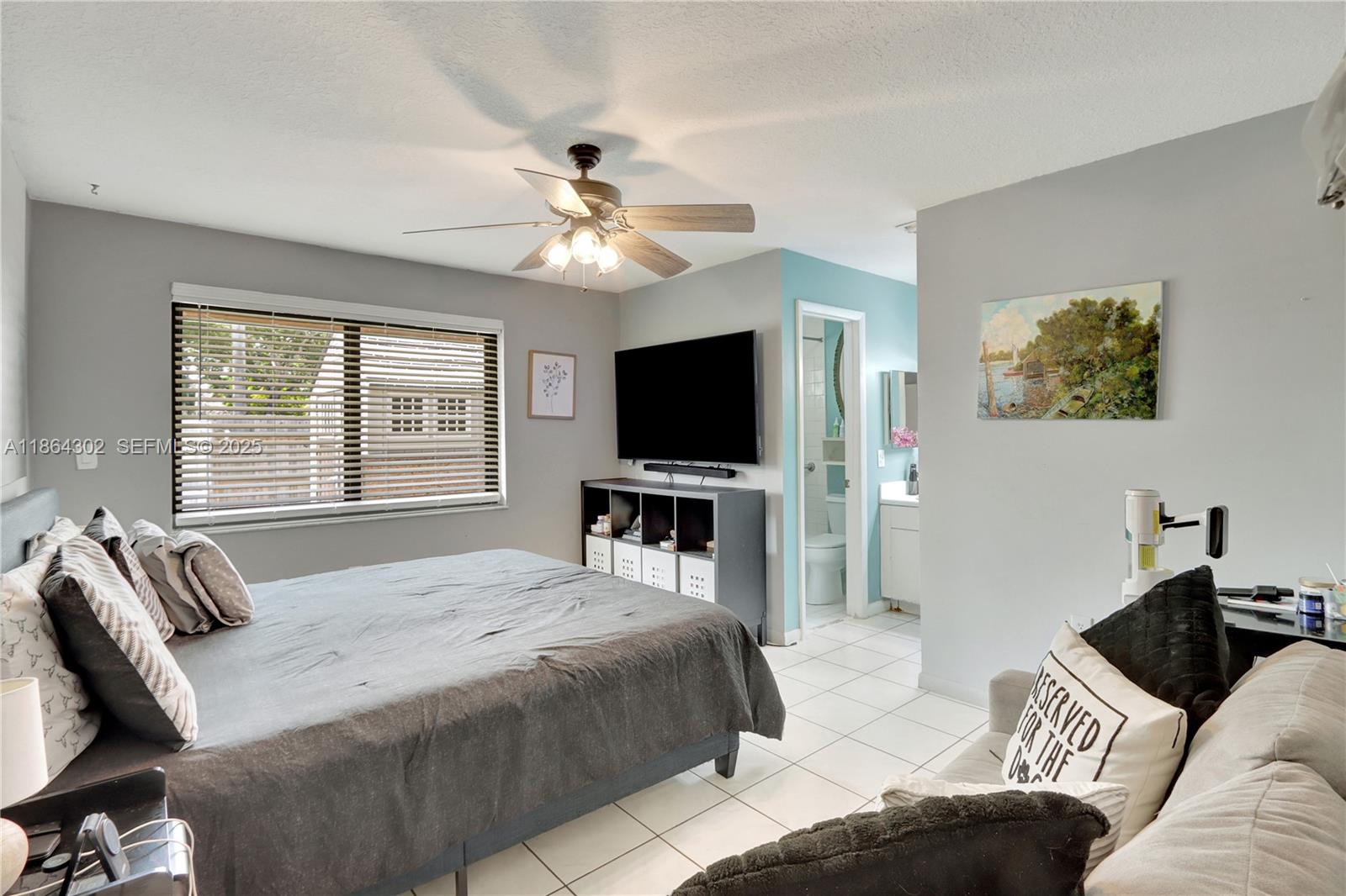7680 Southwest 156th Court, Unit B113 Miami, FL 33193 - Photo 10 of 16 a bedroom with a bed and a flat screen tv