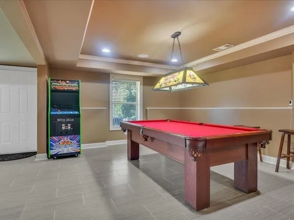 a room with pool table windows and bed