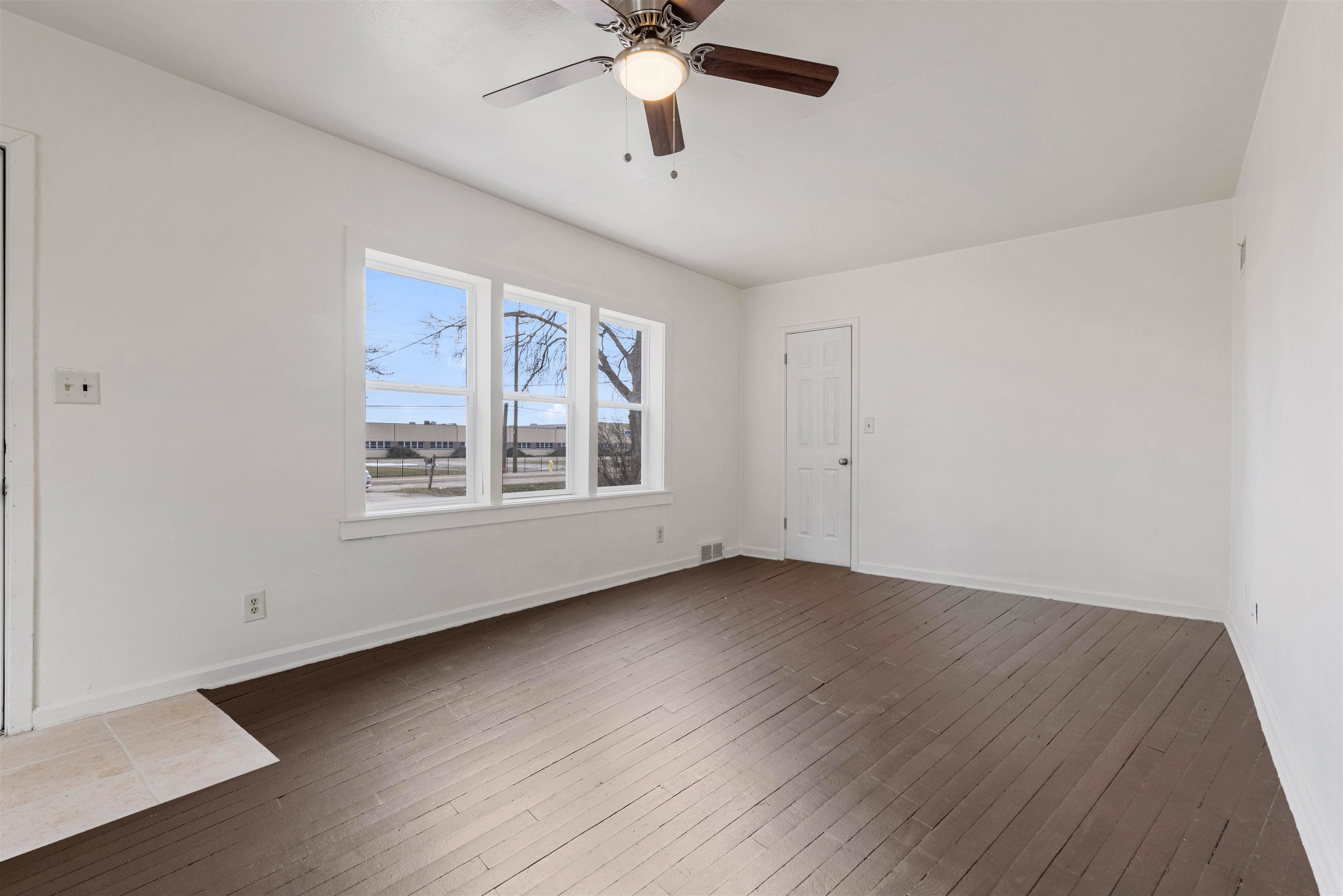 1214 Samuelson Road Rockford, IL 61109 - Photo 2 of 15 an empty room with wooden floor chandelier fan and windows