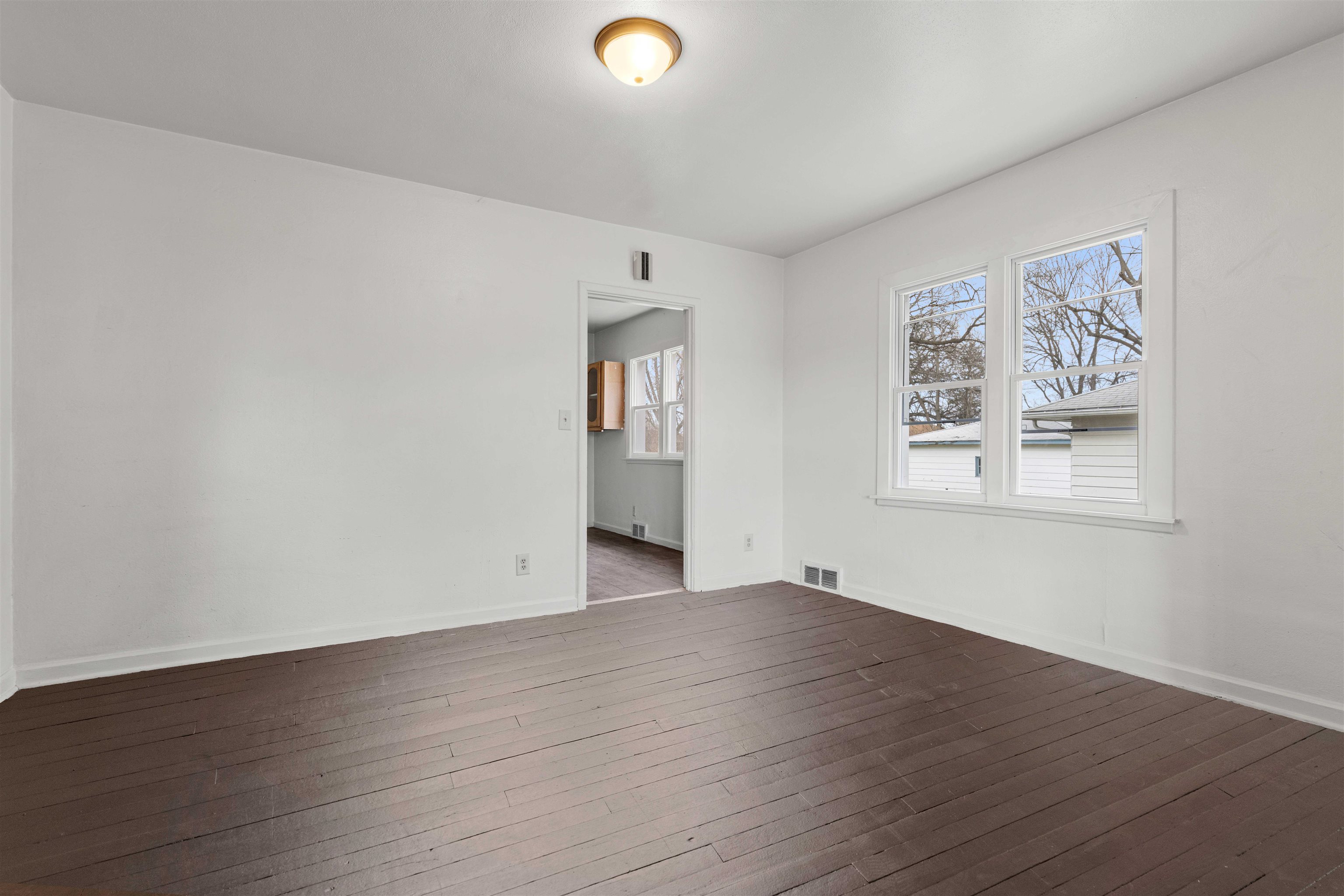 1214 Samuelson Road Rockford, IL 61109 - Photo 4 of 15 a view of an empty room with wooden floor and a window