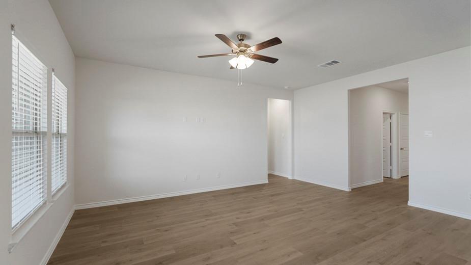 439 Epiphany Lane Lavon, TX 75166 - Photo 13 of 31 Spacious room featuring wood-finish flooring, white baseboards, and a ceiling fan with integrated lighting
