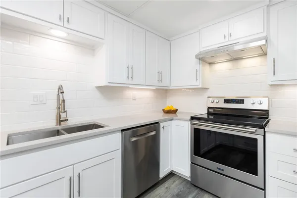 a kitchen with cabinets appliances and a sink