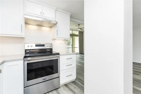 a kitchen with white cabinets and stainless steel appliances