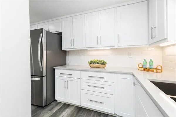 a kitchen with stainless steel appliances white cabinets and a refrigerator