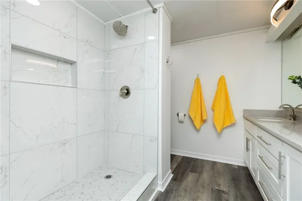 a bathroom with a granite countertop shower a sink and a window
