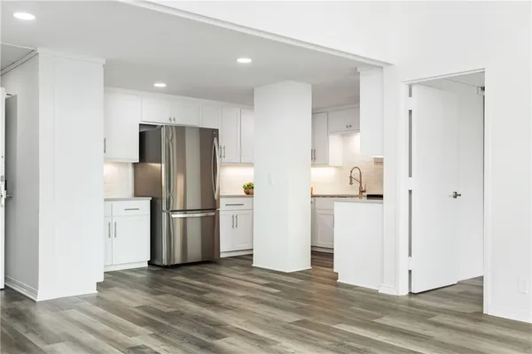 a view of a refrigerator in kitchen and a room