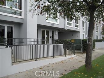 10878 Bloomfield Street, Unit 404 Toluca Lake, CA 91602 - Photo 1 of 36 a view of a house with a small yard and a large tree