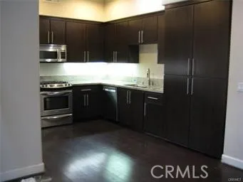 a kitchen with stainless steel appliances granite countertop a refrigerator and a stove