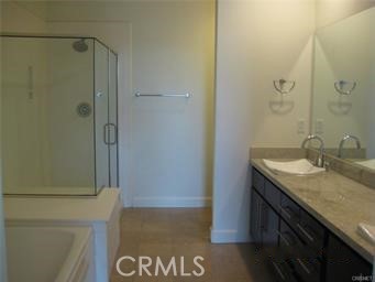 10878 Bloomfield Street, Unit 404 Toluca Lake, CA 91602 - Photo 23 of 36 a bathroom with a granite countertop sink and a mirror