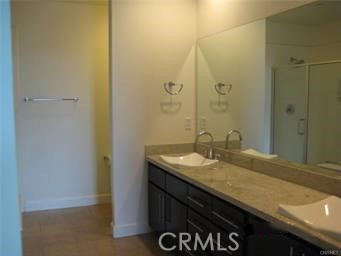10878 Bloomfield Street, Unit 404 Toluca Lake, CA 91602 - Photo 24 of 36 a bathroom with a granite countertop sink and a mirror
