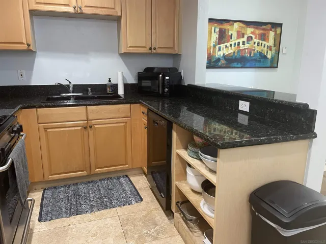 a kitchen with granite countertop a sink and a stove