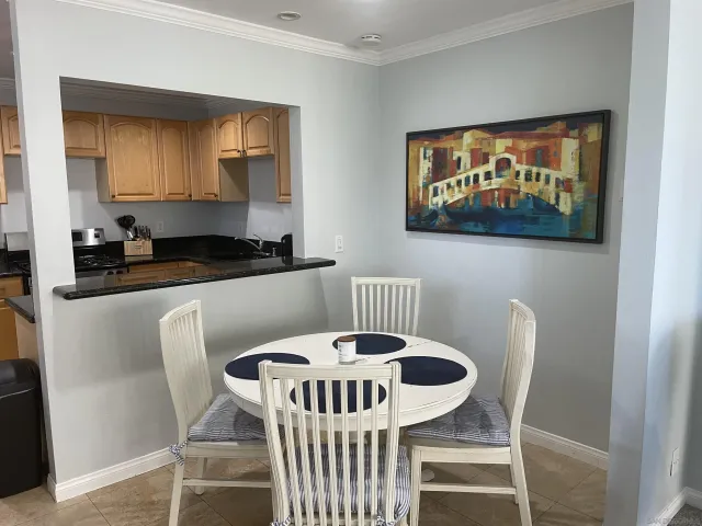 a kitchen with a dining table chairs and a refrigerator
