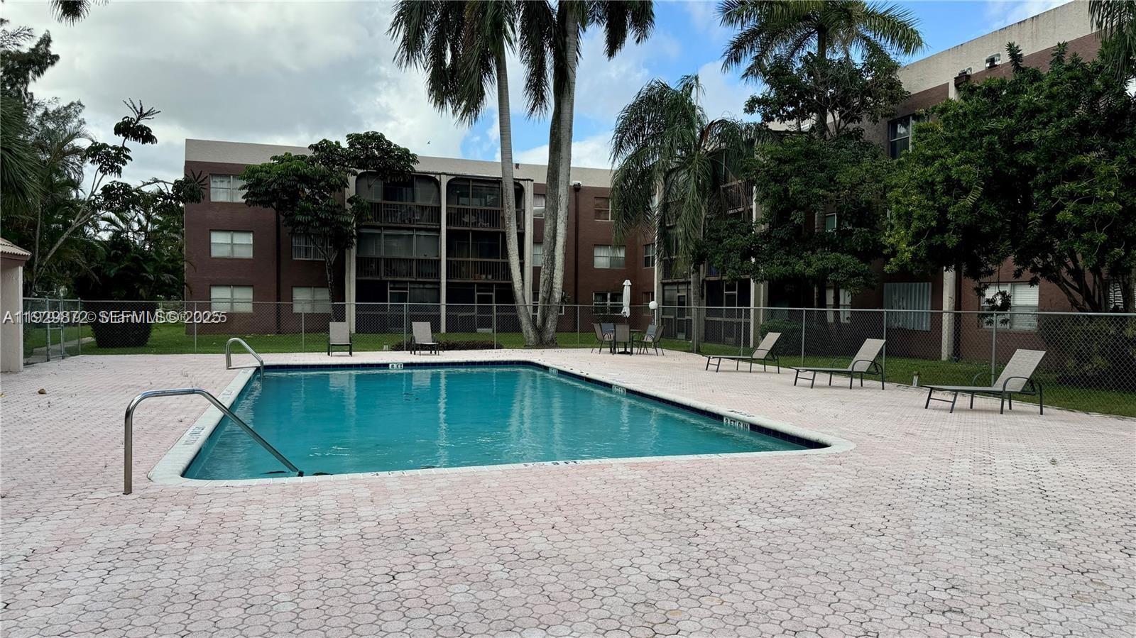 7060 Nova Drive, Unit 306C Davie, FL 33317 - Photo 13 of 17 front view of a house with a swimming pool and a chair