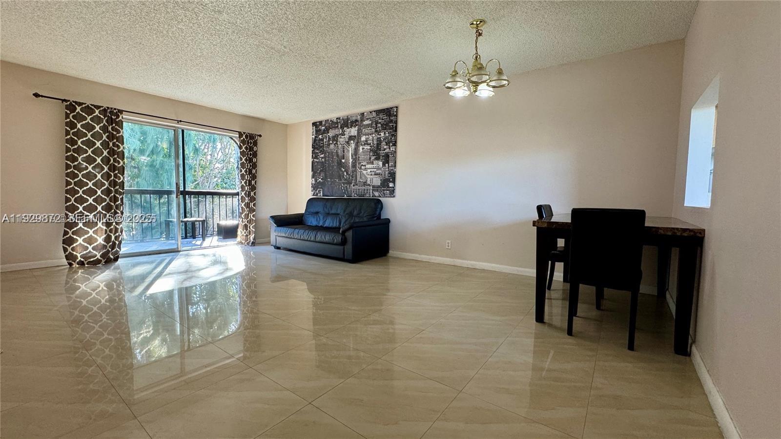 7060 Nova Drive, Unit 306C Davie, FL 33317 - Photo 17 of 17 a living room with furniture and a chandelier