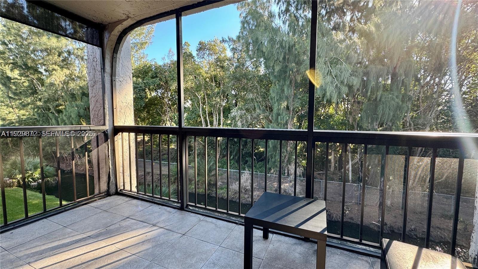 7060 Nova Drive, Unit 306C Davie, FL 33317 - Photo 3 of 17 a view of a balcony with chairs and wooden floor