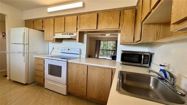 a bathroom with a sink a toilet a window and shower