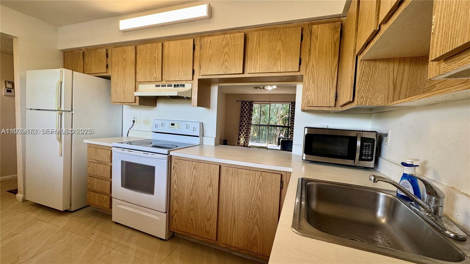 7060 Nova Drive, Unit 306C Davie, FL 33317 - Photo 6 of 17 a kitchen with a refrigerator sink and microwave