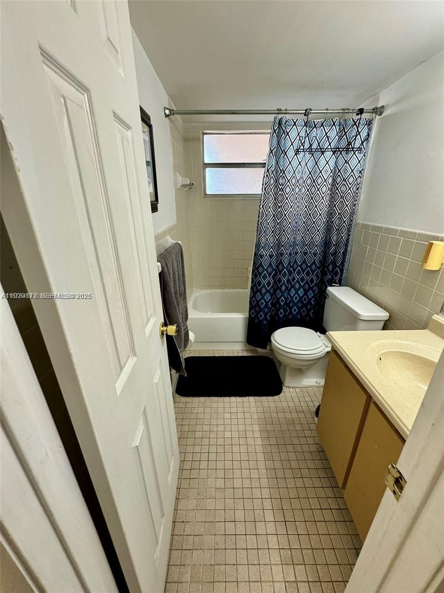 7060 Nova Drive, Unit 306C Davie, FL 33317 - Photo 7 of 17 a bathroom with a sink a toilet a window and shower