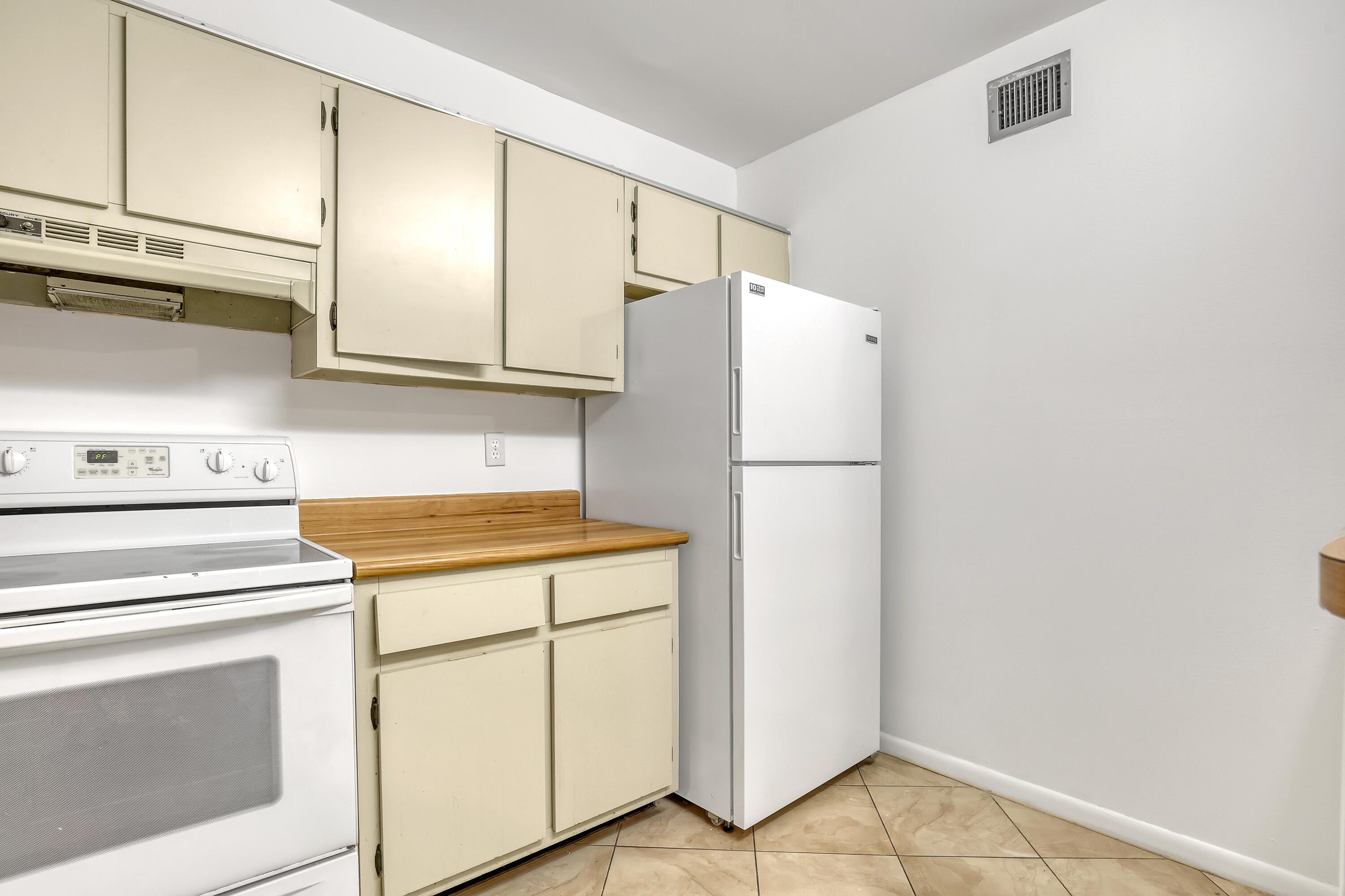 6257 Chasewood Drive, Unit B Jupiter, FL 33458 - Photo 12 of 36 a white refrigerator freezer and a stove sitting inside of a kitchen