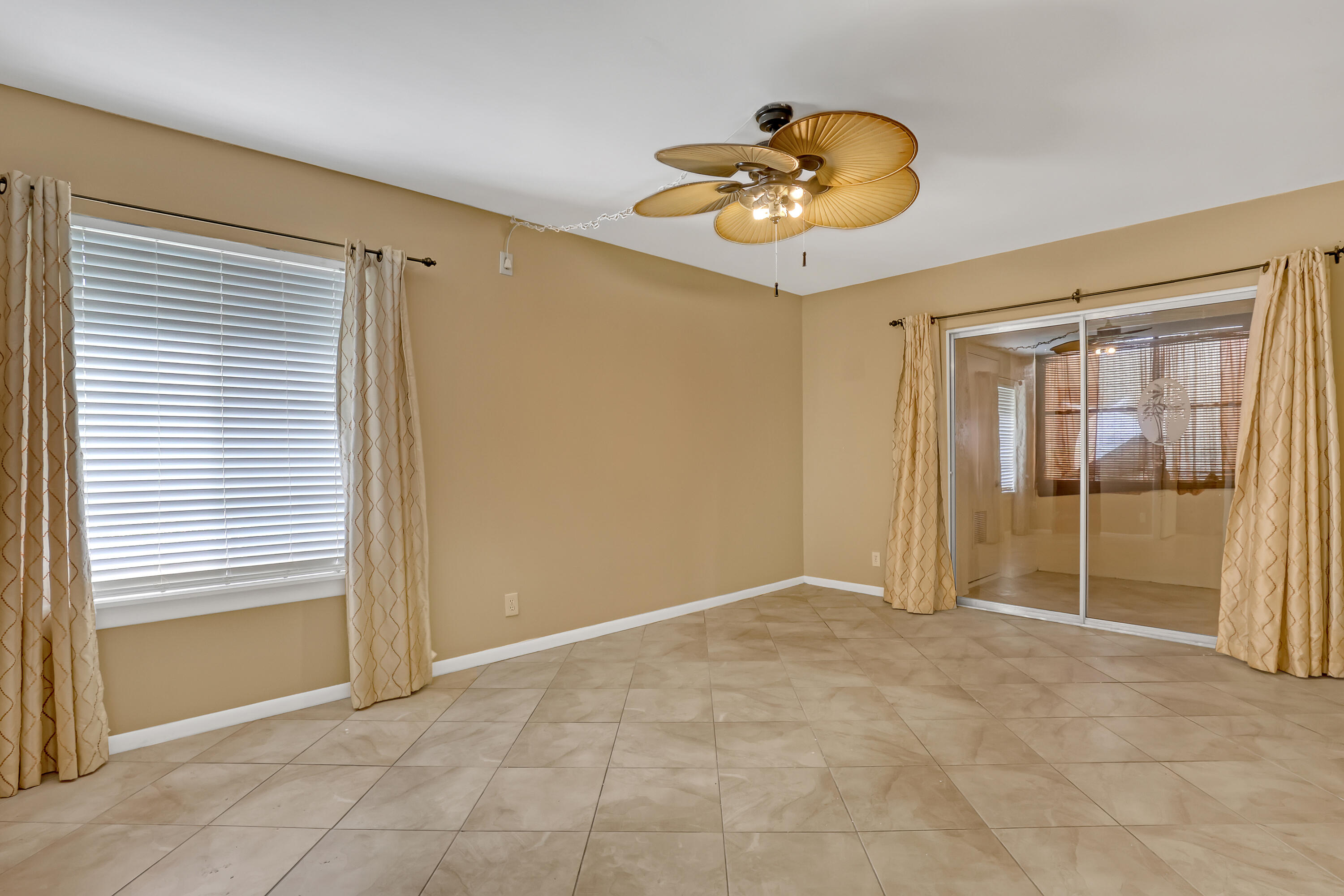 6257 Chasewood Drive, Unit B Jupiter, FL 33458 - Photo 16 of 36 an empty room with window and chandelier