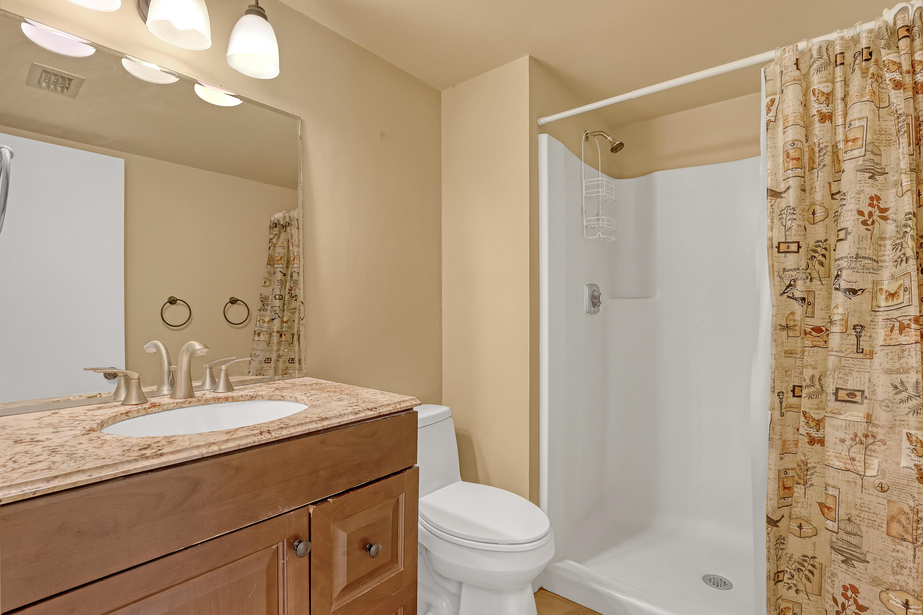 6257 Chasewood Drive, Unit B Jupiter, FL 33458 - Photo 19 of 36 a bathroom with a granite countertop sink a toilet and shower