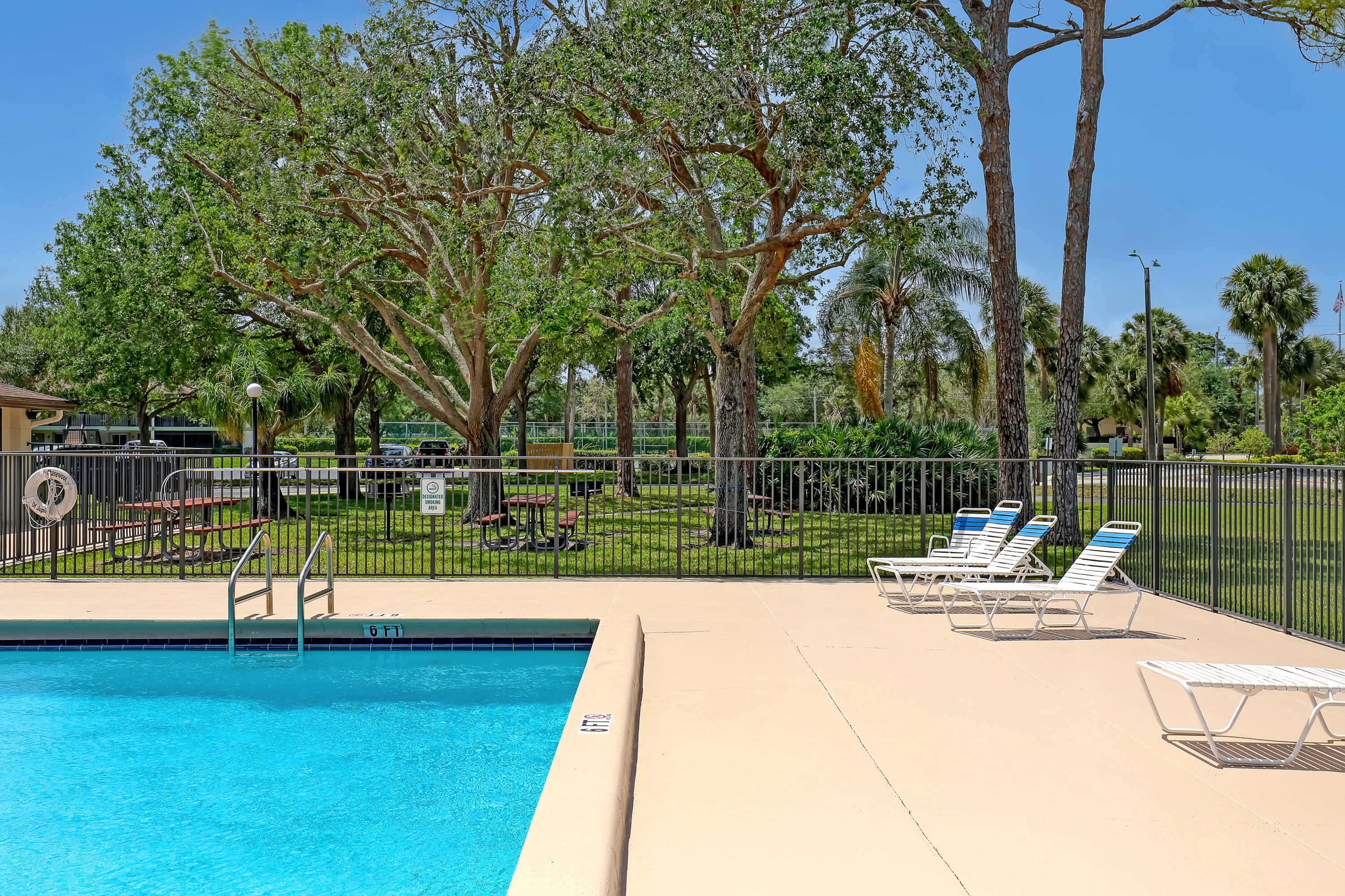 6257 Chasewood Drive, Unit B Jupiter, FL 33458 - Photo 34 of 36 a view of a lake with a bench