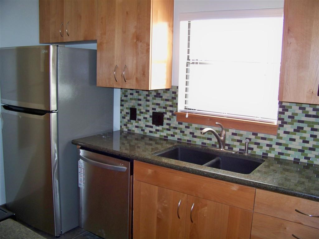 802 South 1st Street, Unit 217 Austin, TX 78704 - Photo 2 of 16 a kitchen with granite countertop stainless steel appliances a refrigerator and a sink