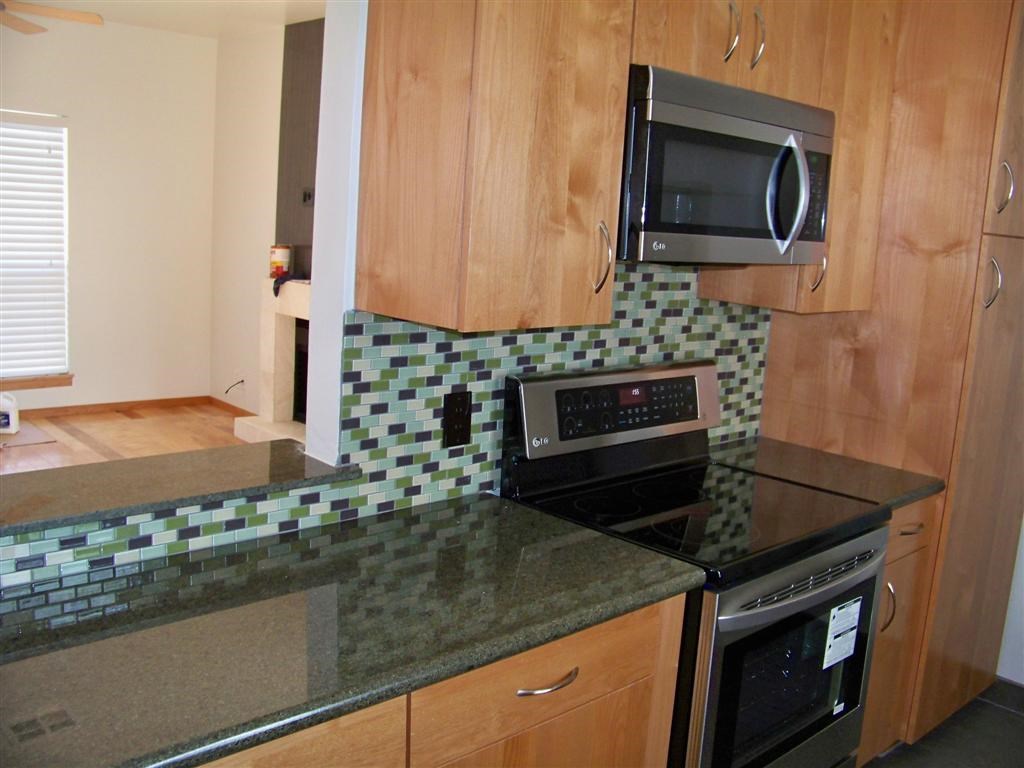 802 South 1st Street, Unit 217 Austin, TX 78704 - Photo 3 of 16 a kitchen with granite countertop a stove and a microwave
