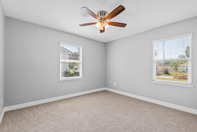 an empty room with a window and a fan
