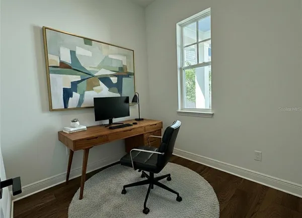 a view of a workspace with furniture and a window