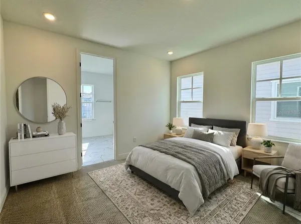 a bedroom with a bed a mirror and lamp
