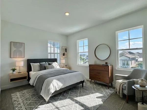 a spacious bedroom with a bed and a lamp