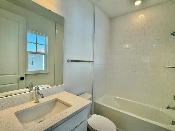 a bathroom with a granite countertop toilet and a sink