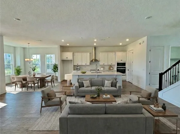 a living room with furniture and a dining table with kitchen view