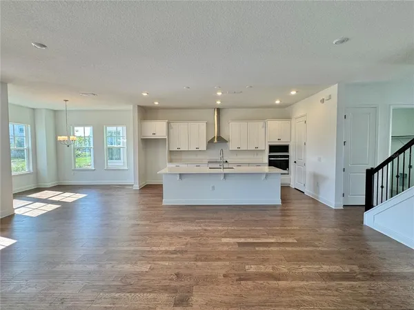 a view of kitchen with kitchen island granite countertop a stove top oven a sink and a refrigerator