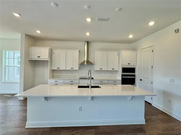 a kitchen with kitchen island sink stove and cabinets