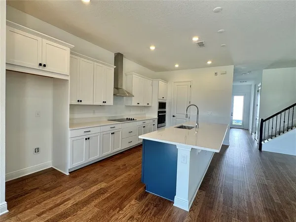 a large kitchen with stainless steel appliances granite countertop a sink and cabinets with wooden floors